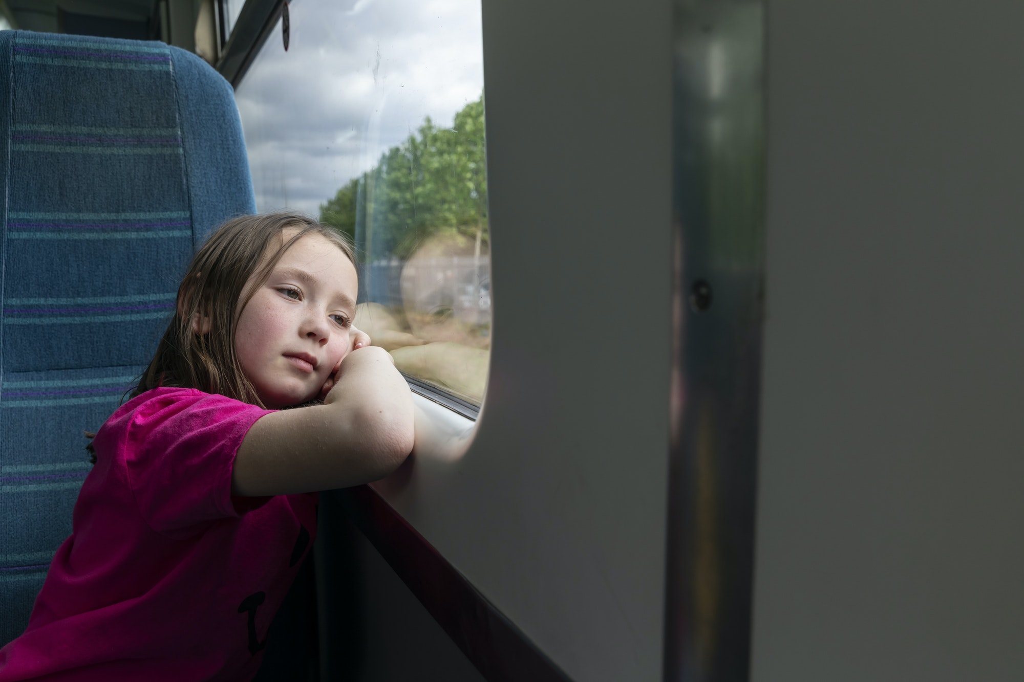 Girl looking through window in train